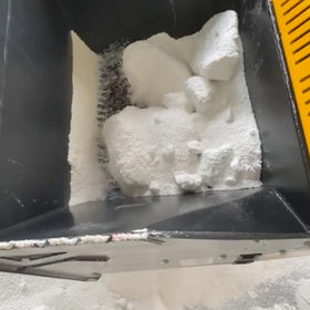 ロータリースクリーニングバケットで凍結防止剤の塩の塊をほぐす様子